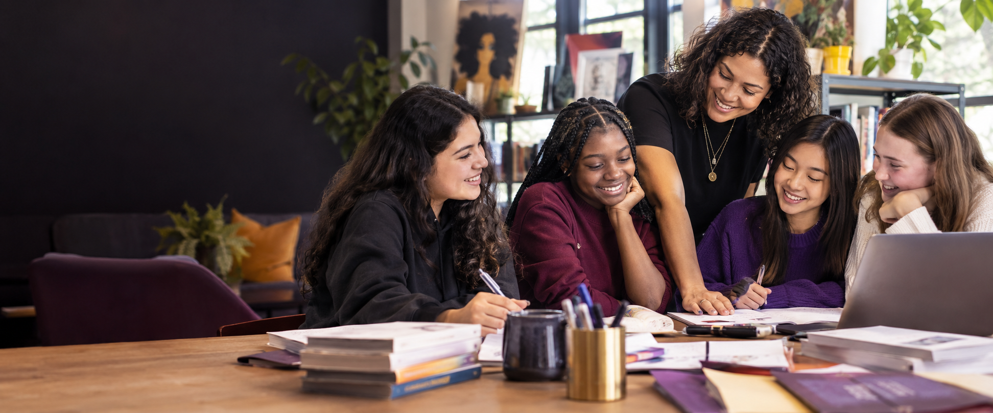 A mentor working with a diverse group of teenage girls